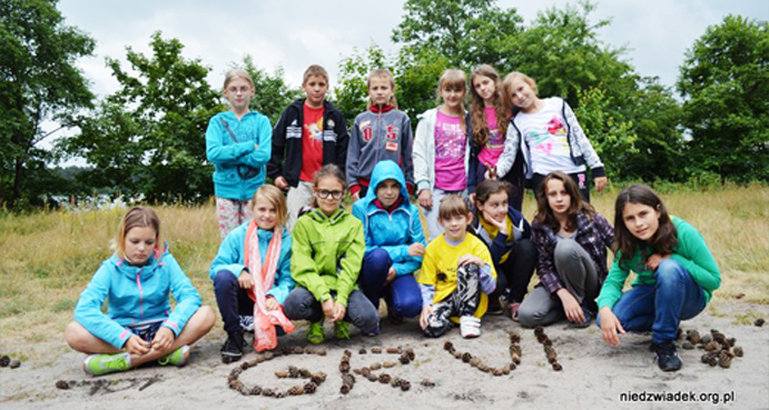 Grupowe zdjęcie usmiechniętych dzieci na wyjeździe